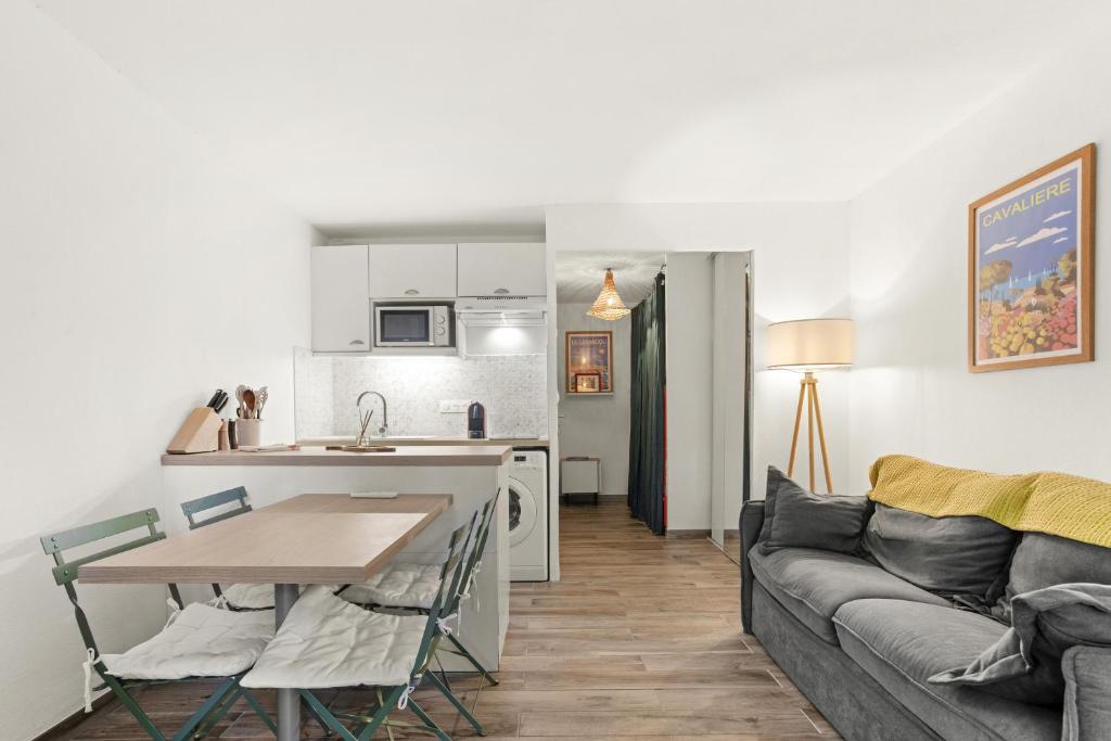 une cuisine et un salon avec un canapé et une table dans l'établissement Appartement Le Lavandou - Cavalière, au Lavandou