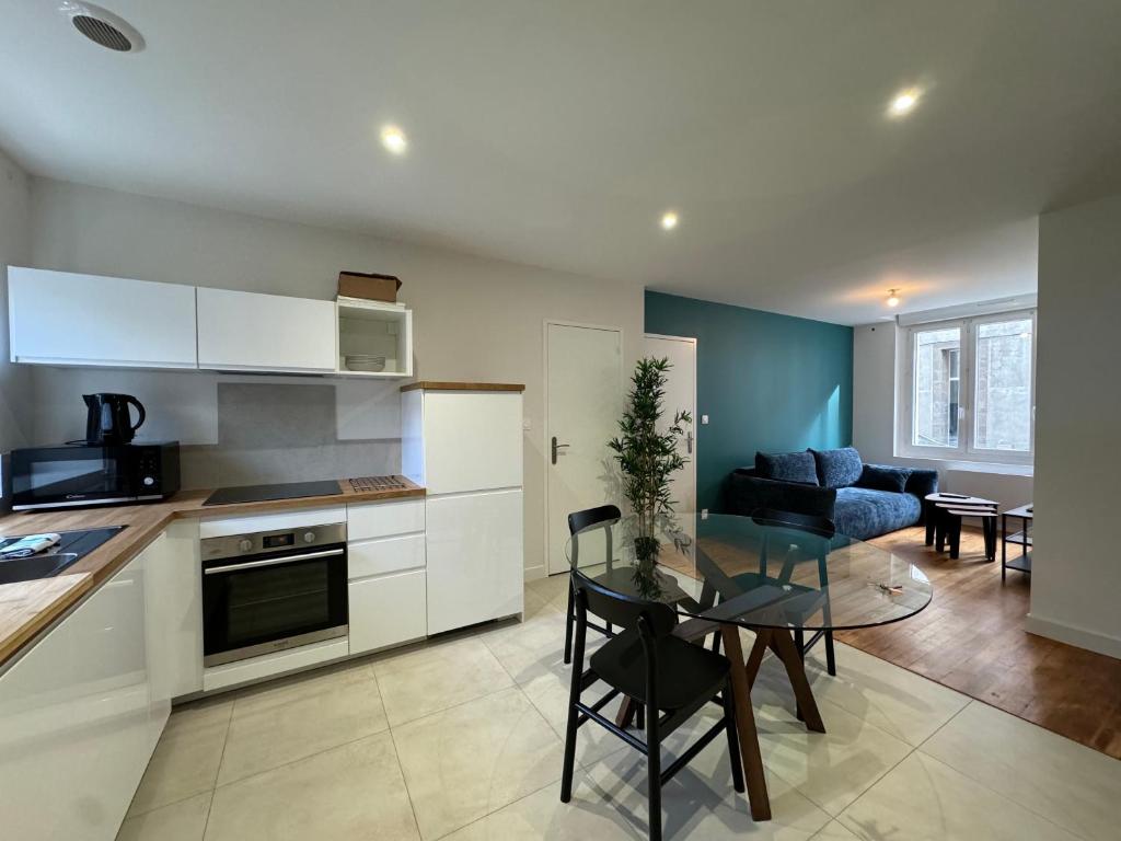 une cuisine et un salon avec une table et un canapé dans l'établissement Appartement contemporain Centre-Ville, à Brest