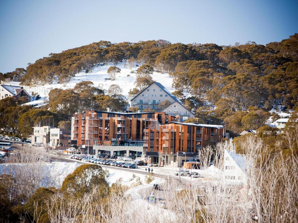 a snowy mountain range with a train on it at QT Falls Creek in Falls Creek