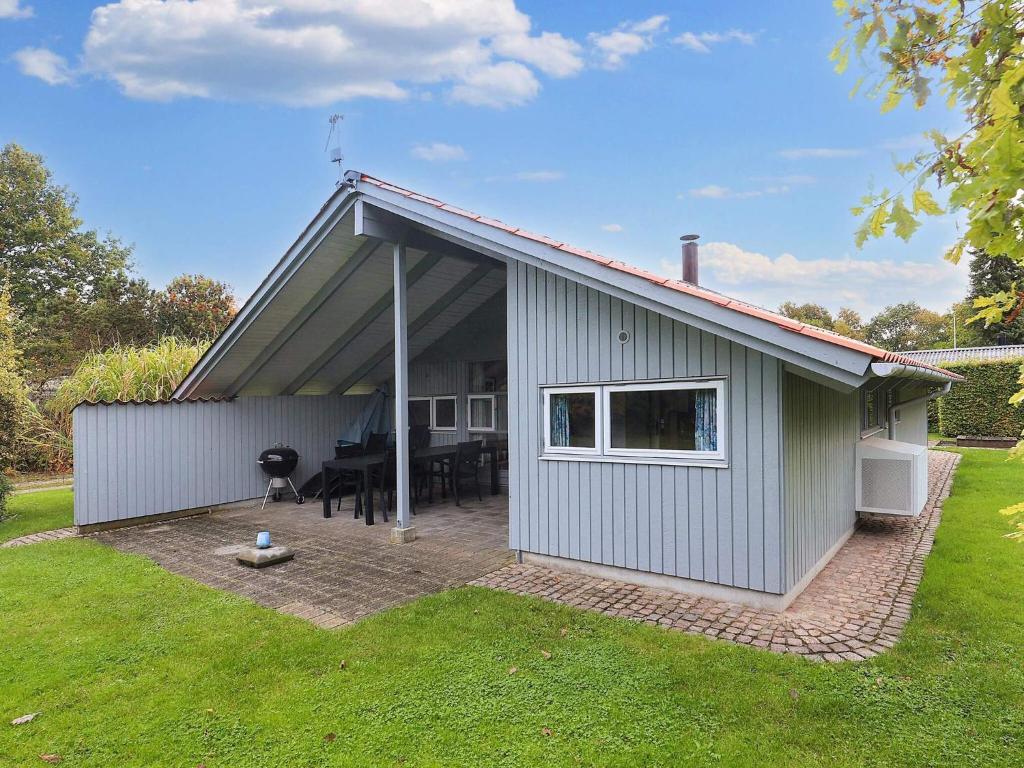 a small house with a patio and a table at 4 star holiday home in Nysted in Nysted
