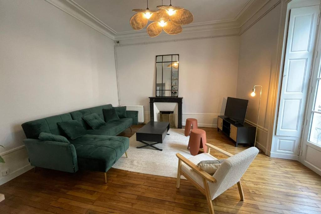 - un salon avec un canapé vert et une cheminée dans l'établissement Spacious T4 in the heart of the city center, à Nantes