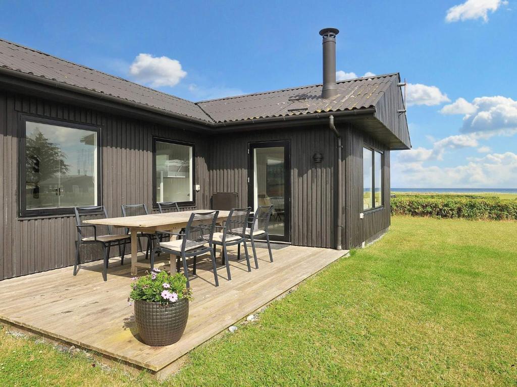 una casa con una mesa y sillas en una terraza en 4 star holiday home in Sæby-By Traum, en Saeby