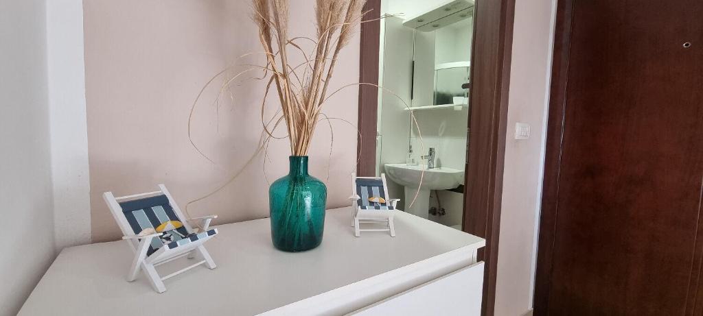 zielony wazon na ladzie z dwoma krzesłami w obiekcie Apartment Mani w mieście Ližnjan