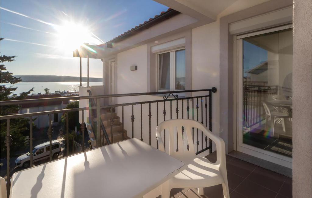 a balcony with a white table and chairs and the sun at Awesome Apartment In Crikvenica in Crikvenica