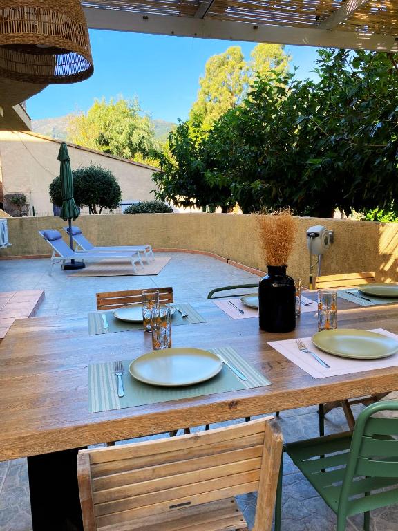 une table en bois avec des plaques blanches au-dessus dans l'établissement U Fiume - Appartement 5 personnes, à San-Martino-di-Lota