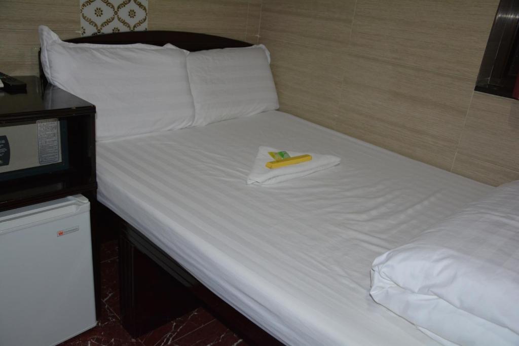 Una cama con un plátano y una servilleta. en Everest Guest House, en Hong Kong