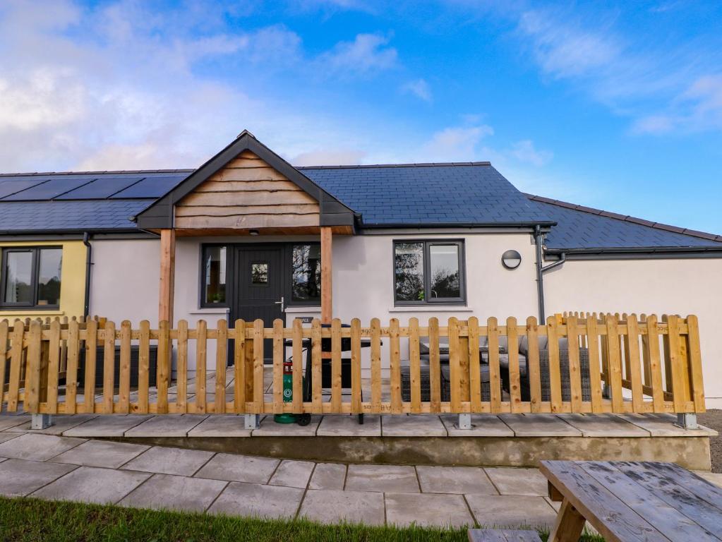 a house with a wooden fence in front of it at Lobster Cottage in Saundersfoot