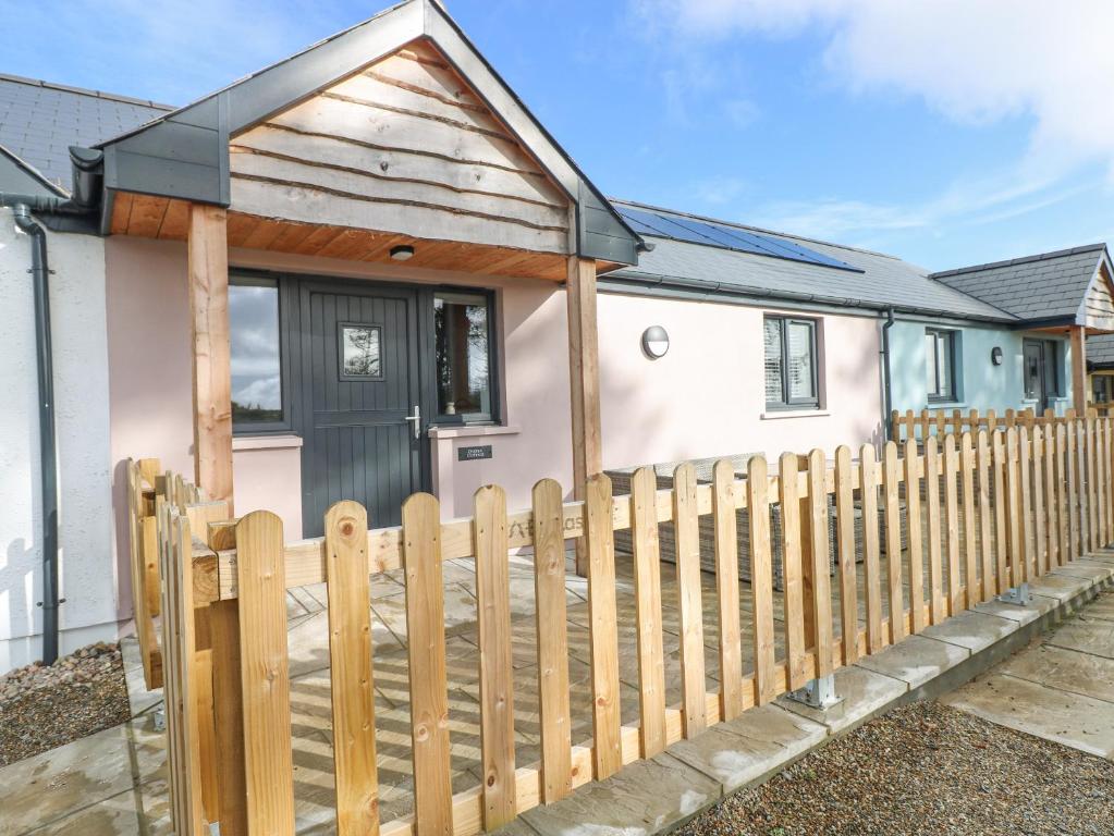 a wooden fence in front of a small house at Oyster Cottage in Saundersfoot