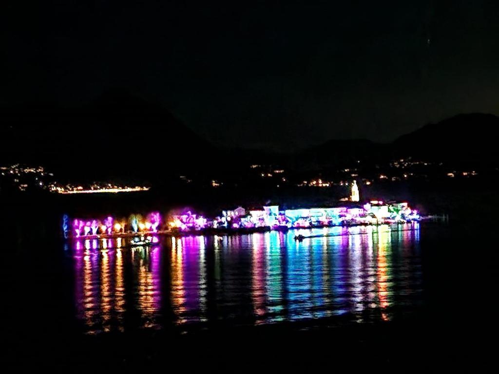 a night view of a city with lights on the water at Apartment camelie with private beach in Baveno