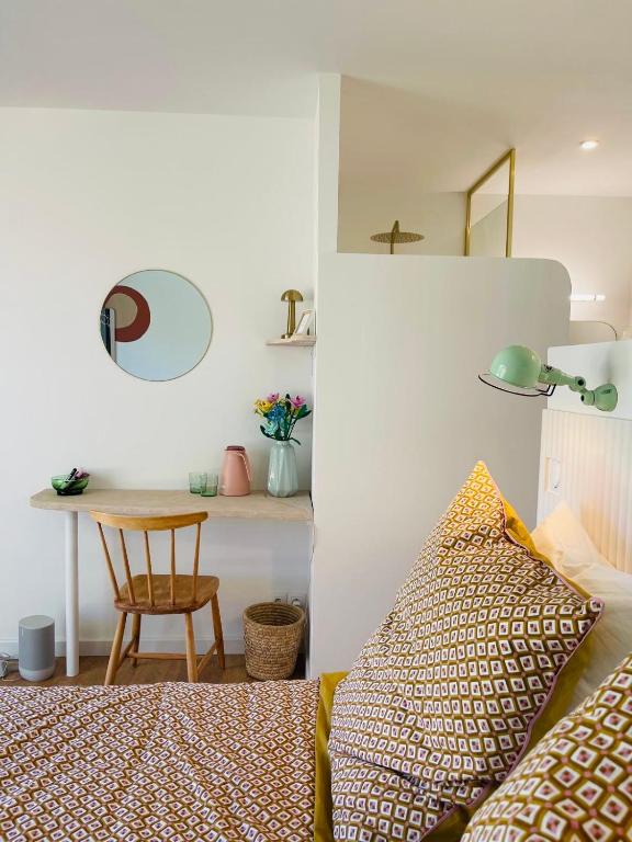 une chambre avec un lit et une table avec une chaise dans l'établissement Le Petit Mas Roc, à Saint-Maximin-la-Sainte-Baume