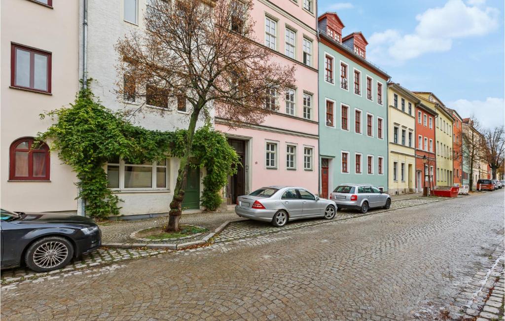 two cars parked on a cobblestone street next to buildings at Pet Friendly Apartment In Naumburg in Naumburg