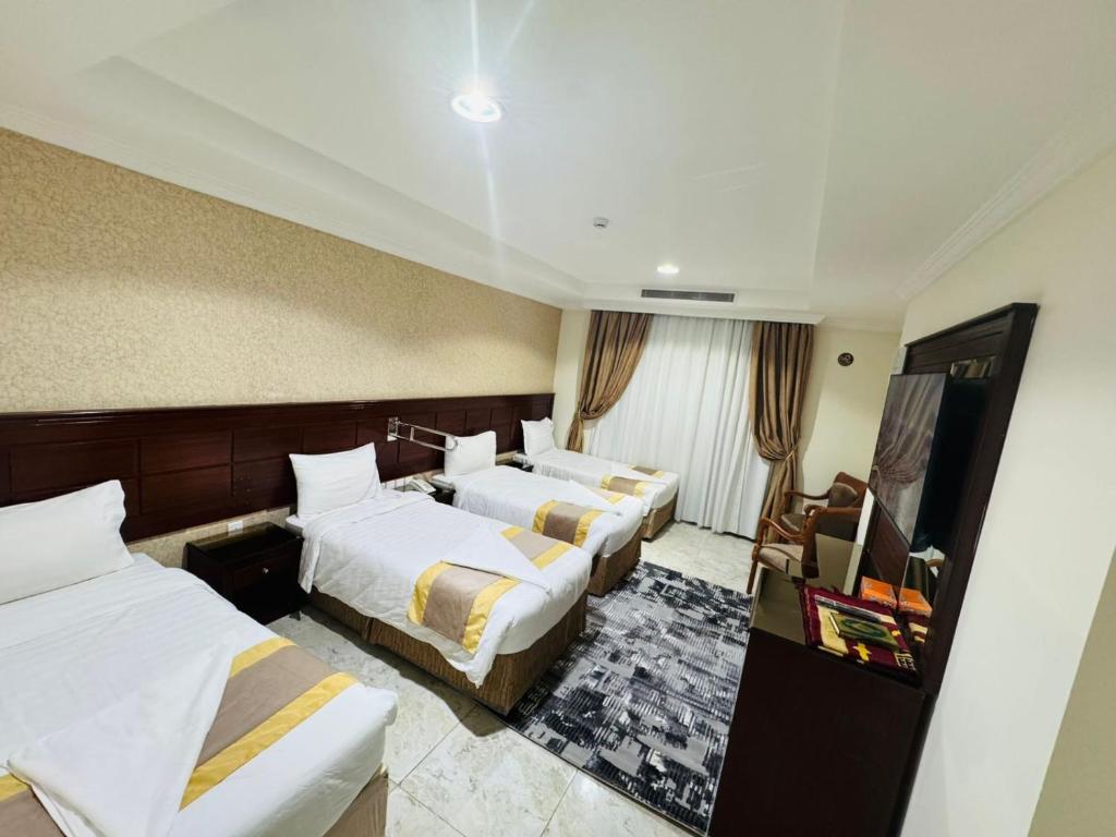 a hotel room with two beds and a television at فندق الركائز in Makkah
