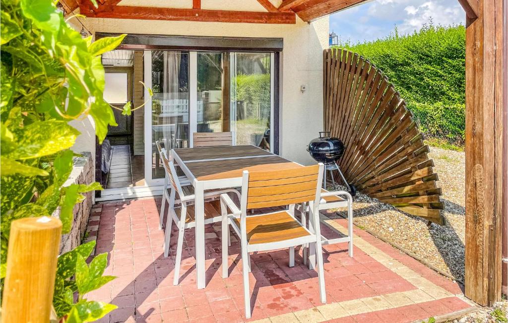 Una mesa y sillas de madera en un patio. en Awesome Home In Criquetot-L'esneval, en Criquetot-lʼEsneval