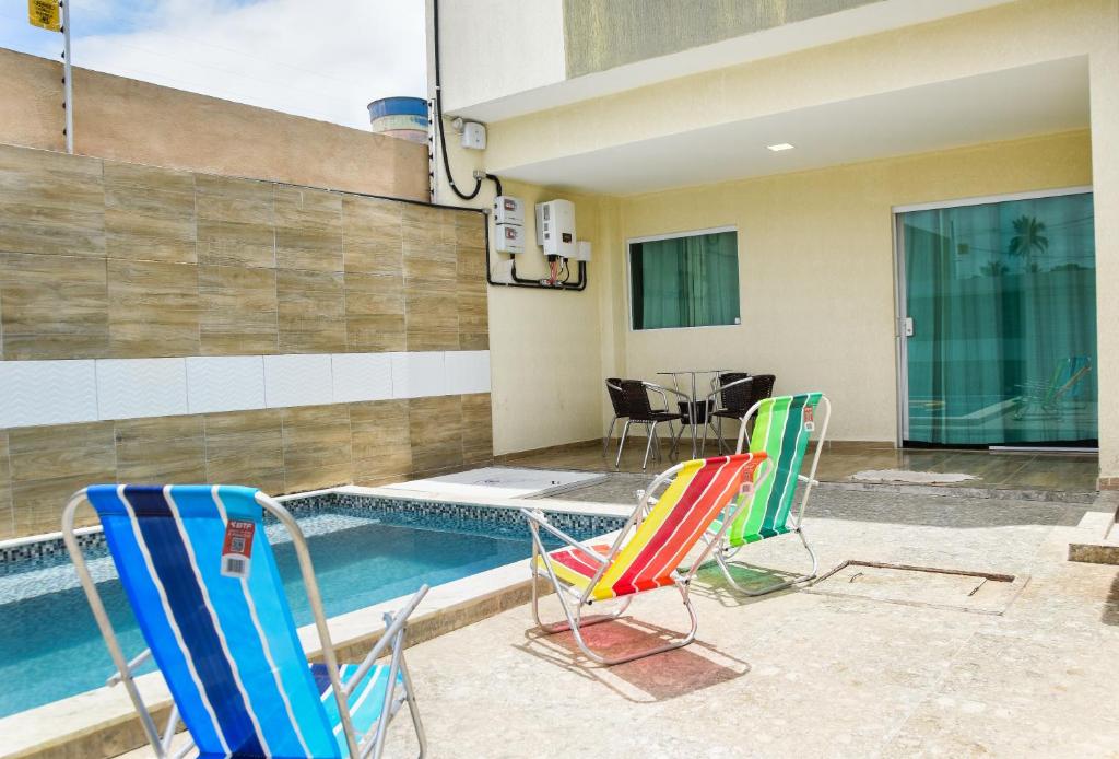 ein paar Stühle und ein Pool in der Unterkunft Casa Da Onda in Tamandaré
