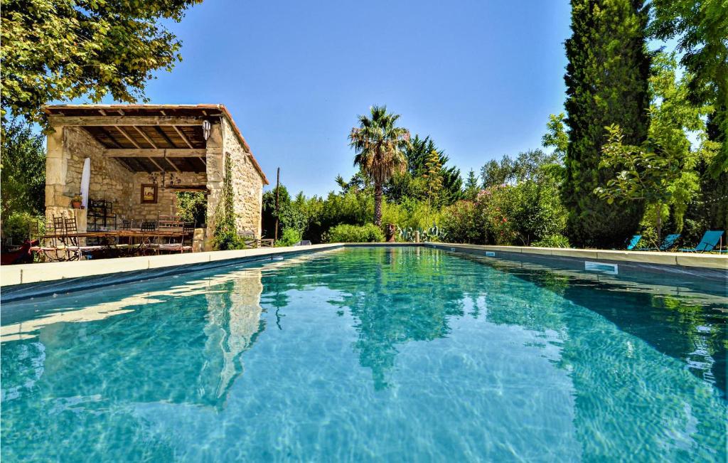 a swimming pool with blue water in front of a building at Five Bedroom Gorgeous Home In Tarascon in Tarascon