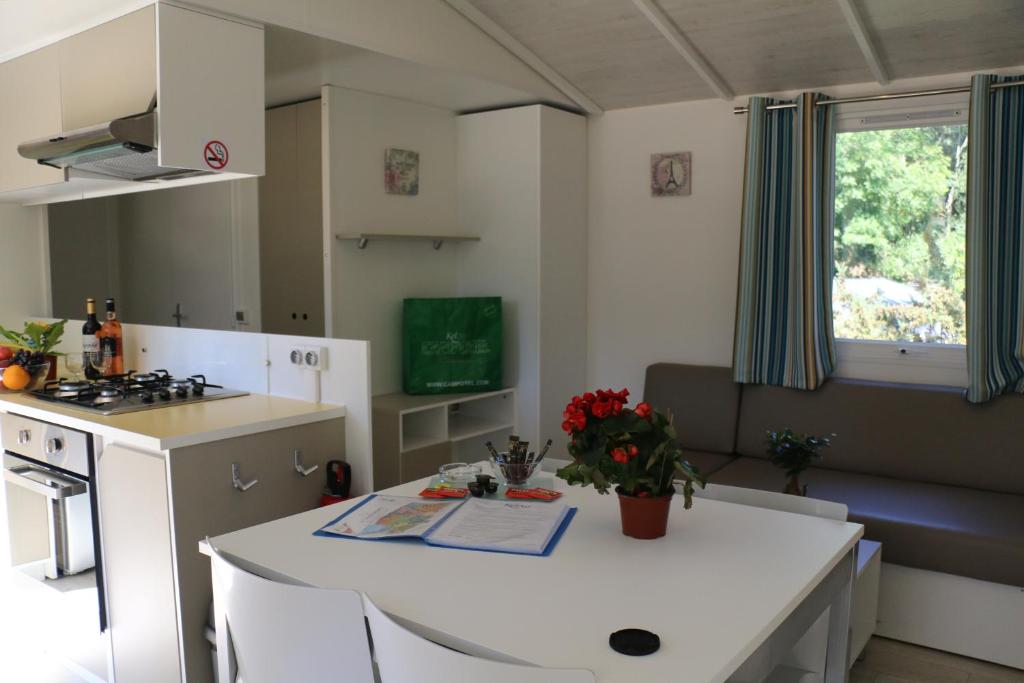 a kitchen and living room with a white counter top at Mobile Homes by KelAir at Camping Sylvamar in Labenne