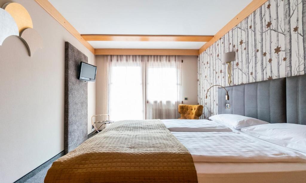 a bedroom with a large bed and a window at Garni Aritz in Campitello di Fassa