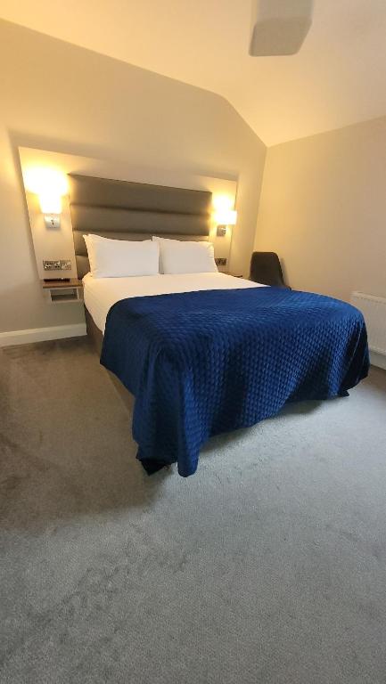 a bedroom with a large bed with a blue blanket at Murphy's Pub and Bed & Breakfast in Dingle