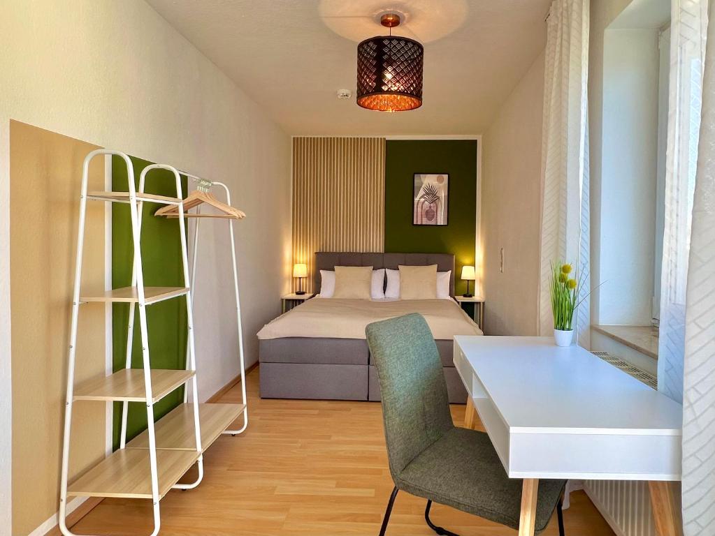 a bedroom with a bed and a desk and a table at Modernes Apartment mit Balkon in Neu Ulm