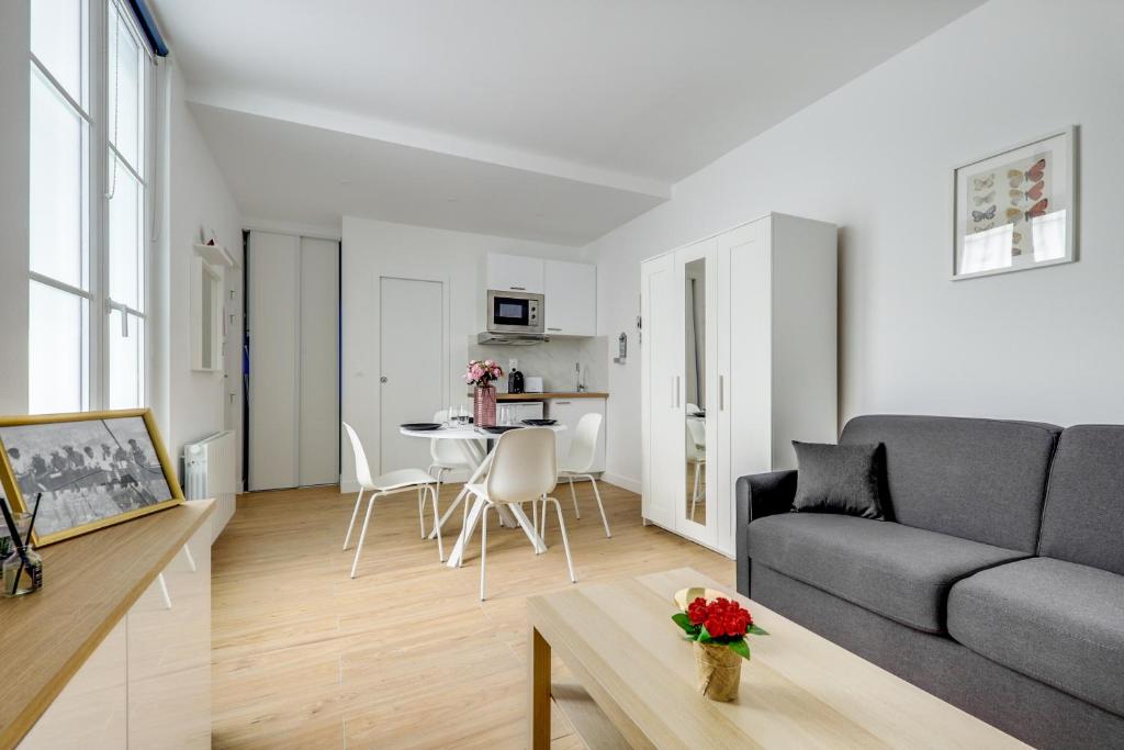 un salon avec un canapé et une table dans l'établissement Center of Paris l Fully equipped and Cozy, à Paris