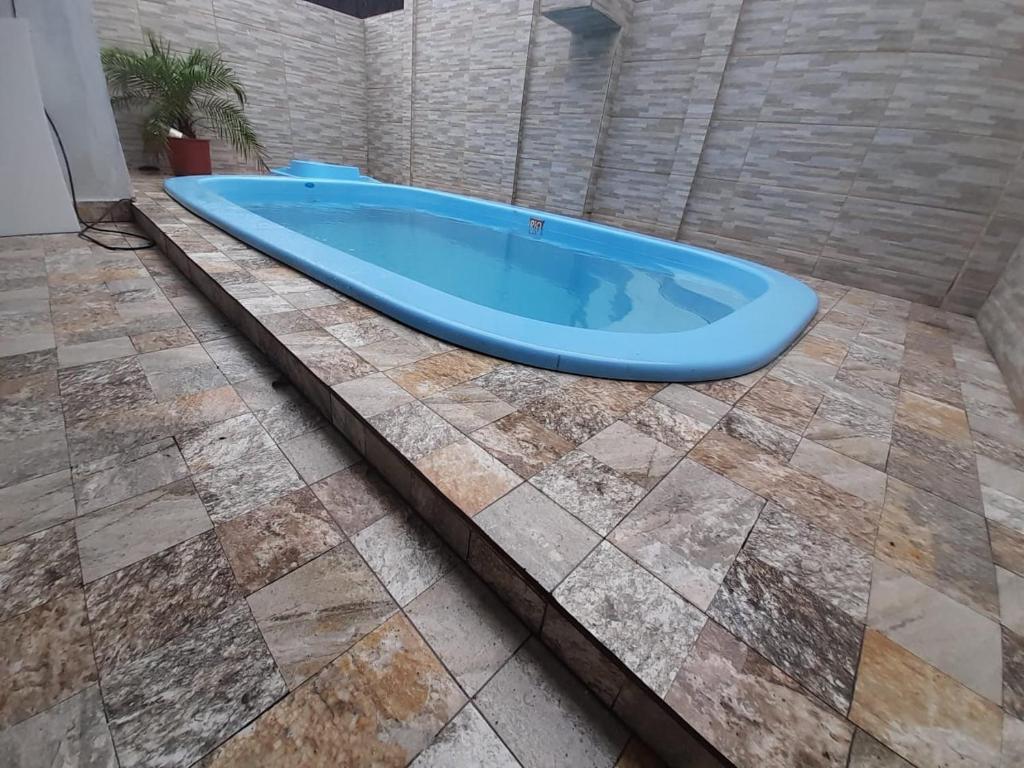 a bath tub sitting on top of a tile floor at Casa com piscina em Bertioga 700m da praia in Bertioga