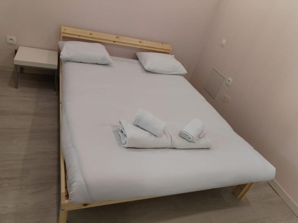 - un grand lit blanc avec 2 serviettes dans l'établissement Logement calme et spacieux, à Villejuif
