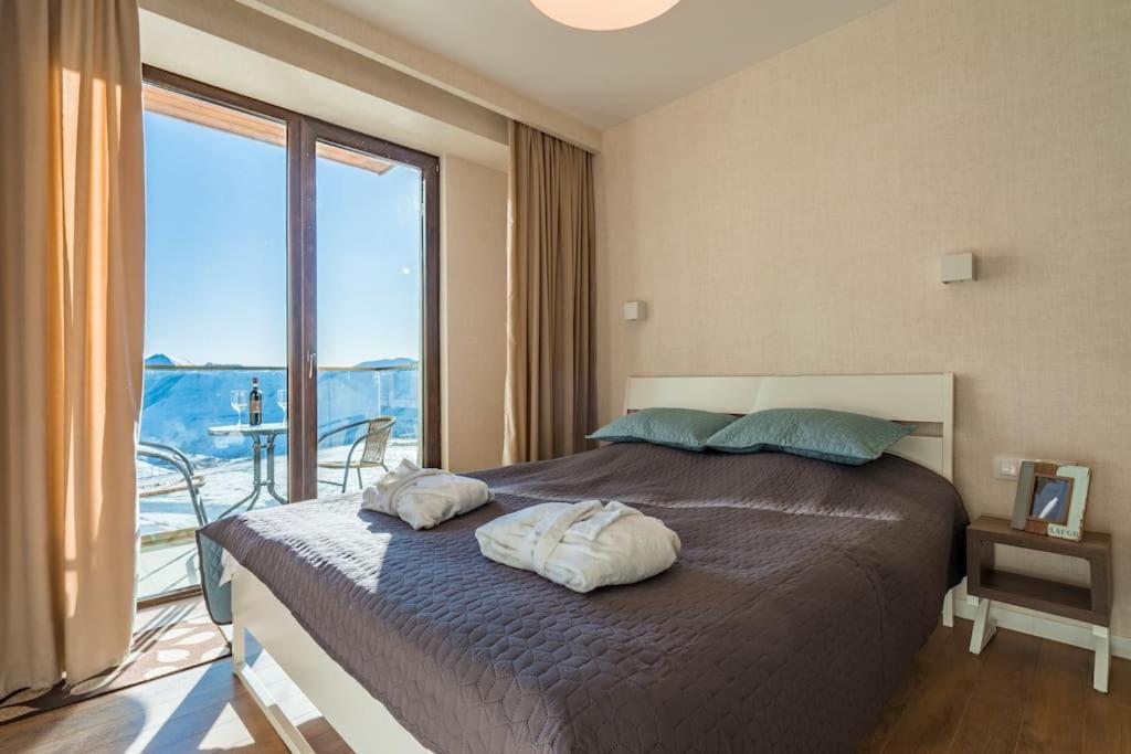 New Gudauri Studio near main Gondola lifts في غودواري: غرفة نوم بها سرير ونافذة كبيرة
