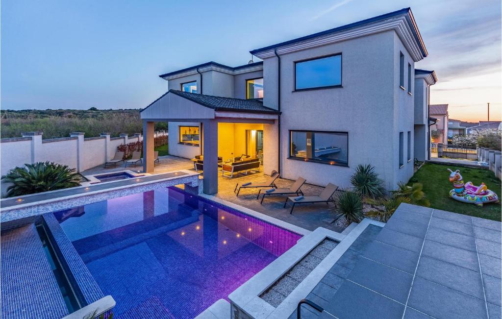 a house with a swimming pool in front of a house at Beautiful Home In Banjole in Banjole