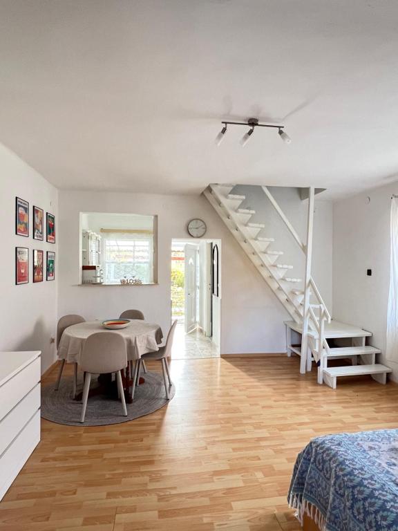 a white room with a table and a staircase at Pipacs in Balatonszárszó