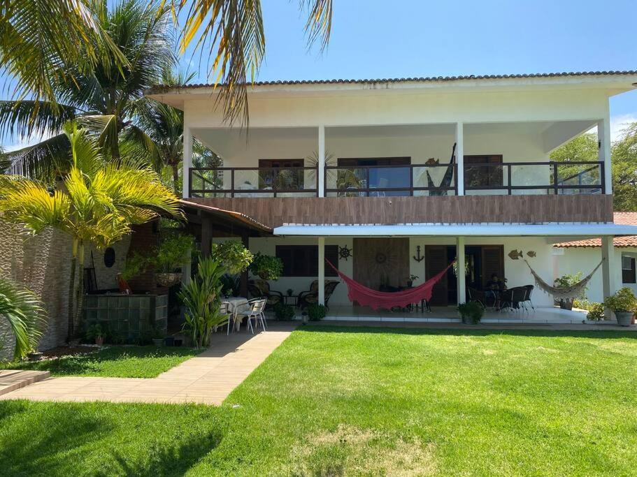 ein großes Haus mit Hängematte im Hof in der Unterkunft Casa pé na areia na praia de Antunes em Maragogi in Maragogi