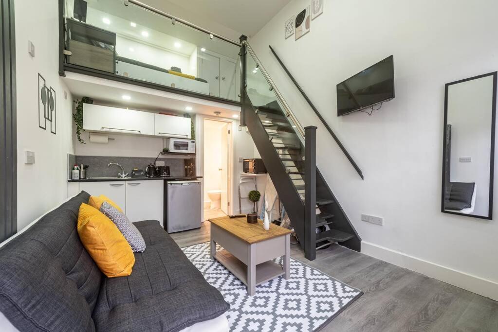 a living room with a couch and a kitchen at Studio in Central Reading- Next to Town Centre in Reading