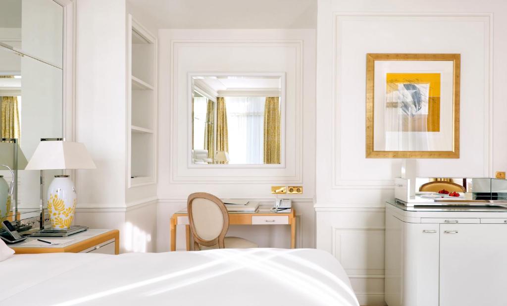 a white bedroom with a bed and a desk at Grand-Hôtel du Cap-Ferrat, A Four Seasons Hotel in Saint-Jean-Cap-Ferrat