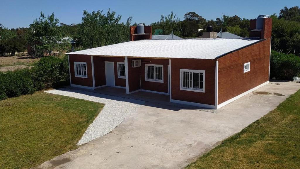 una casa pequeña está sentada en una entrada en duplex playa marisol, en Balneario Oriente
