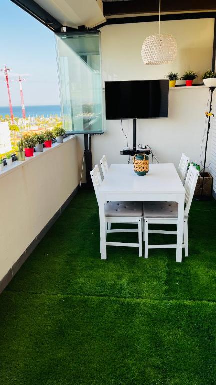 A television and/or entertainment centre at Ático con Piscina y Vistas al Mar Habitat Litoral