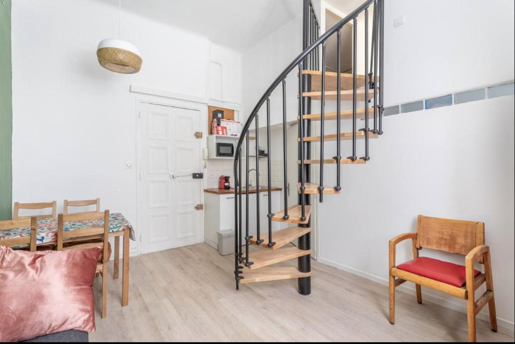 - un escalier en colimaçon dans un salon avec une table et des chaises dans l'établissement 5BAL - Appartement avec Mezzanine, à Marseille