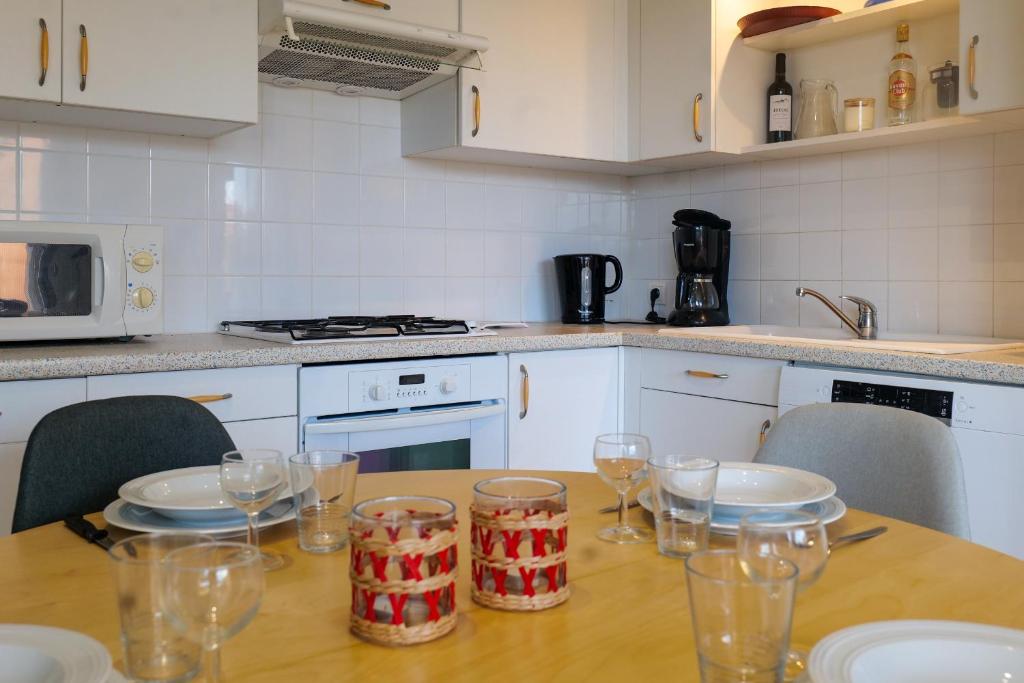 - une cuisine avec une table en bois et des verres dans l'établissement jolie maison avec jardin la pironniere 6 personnes, à Les Sables-dʼOlonne