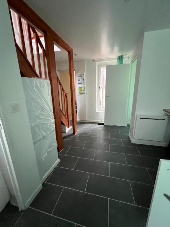 - un couloir avec du carrelage dans une maison dans l'établissement Victor Hugo, à Avesnes-sur-Helpe