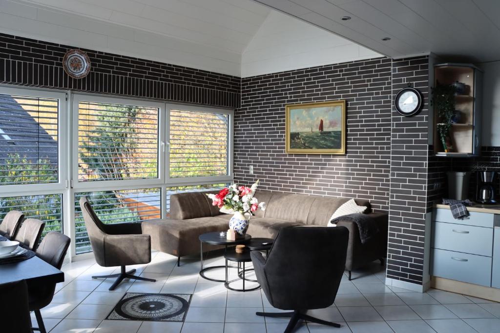 a living room with a couch and a brick wall at Haus Indy in Gemünden
