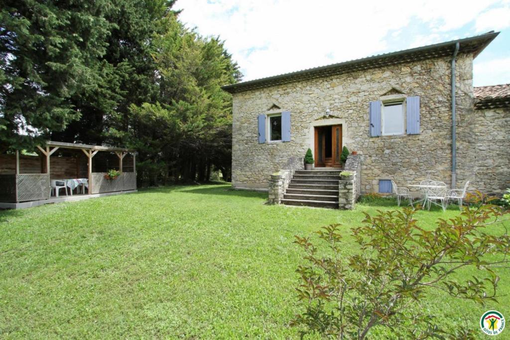 a stone house with a lawn in front of it at Gite le Sagnac 4 personnes in Sauzet