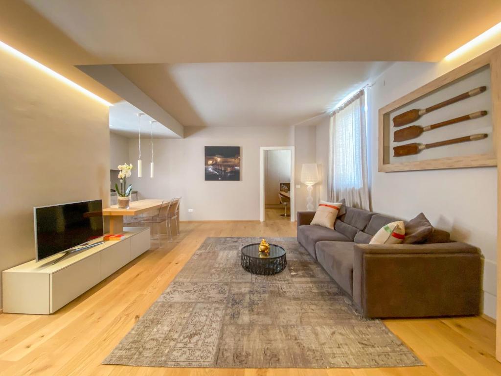 a living room with a couch and a television at Time to Be - Luxury Apartments Centro Storico in Peschiera del Garda