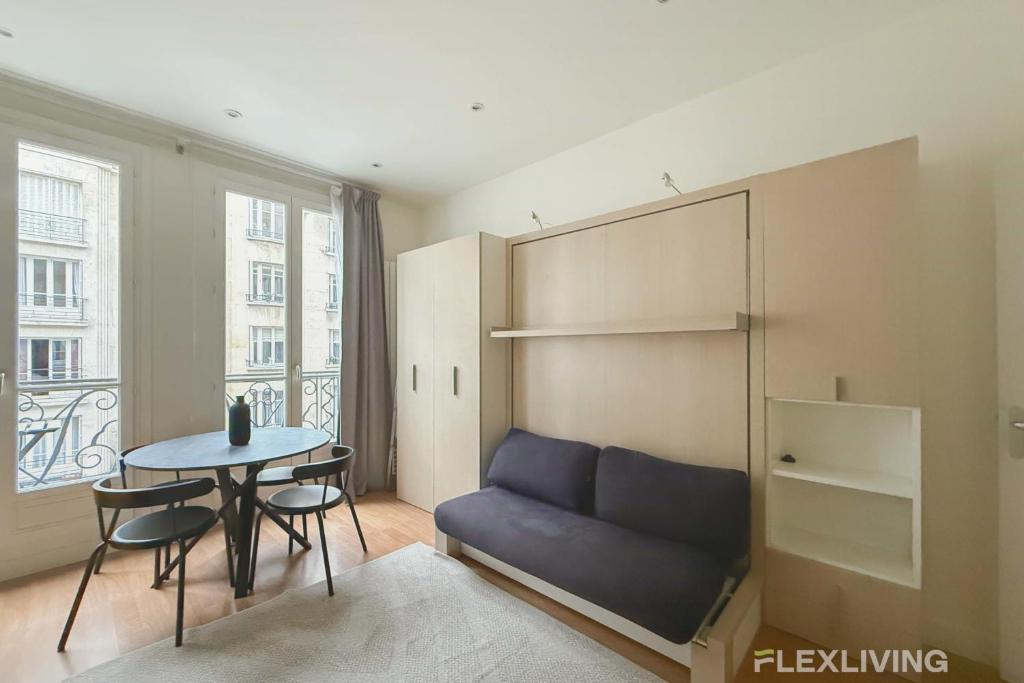 un salon avec un canapé et une table dans l'établissement Flexliving - Dardanelles - Studio, à Paris