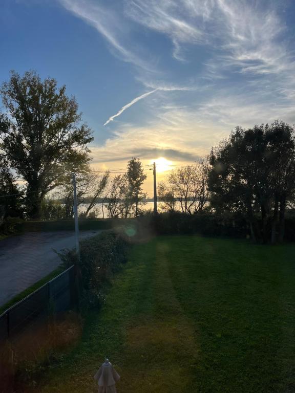 une vue d'un champ avec le coucher de soleil en arrière-plan dans l'établissement Dordogne, à Saint-André-de-Cubzac