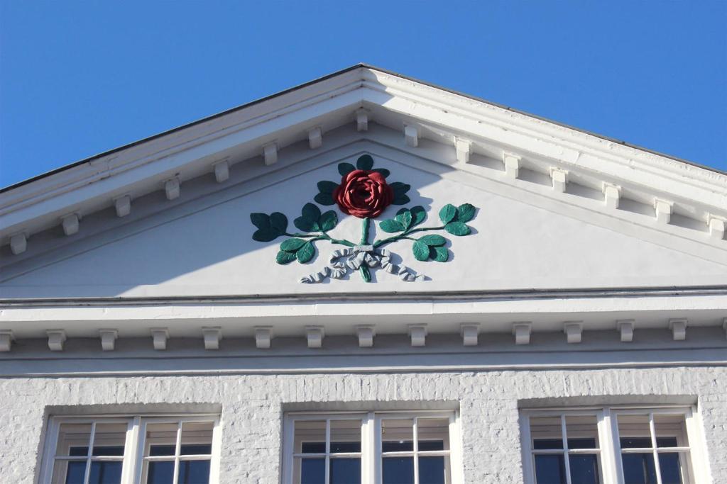 a red rose on the side of a white building at Guesthouse Maison de la Rose in Bruges