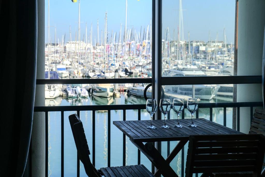 - une table avec des verres à vin sur un balcon avec un port de plaisance dans l'établissement Studio rénové face au Port Olona Les Sables d'Olonne - 4 personnes, à Les Sables-dʼOlonne