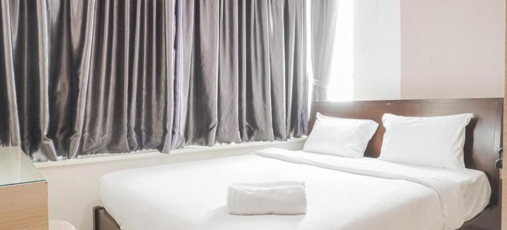 a bedroom with two beds with white sheets and pillows at Stunning Comfy Condominium High Floor at the Heart of Central Jakarta in Jakarta