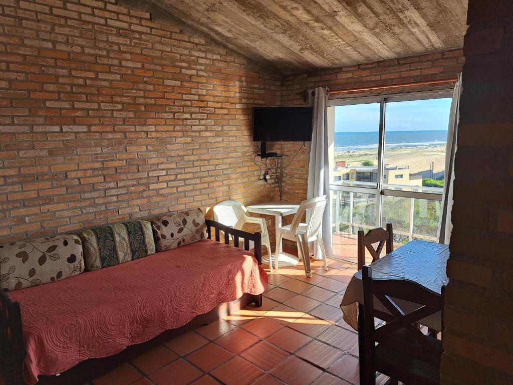 a living room with a couch and a table at El Tridente in Punta Del Diablo