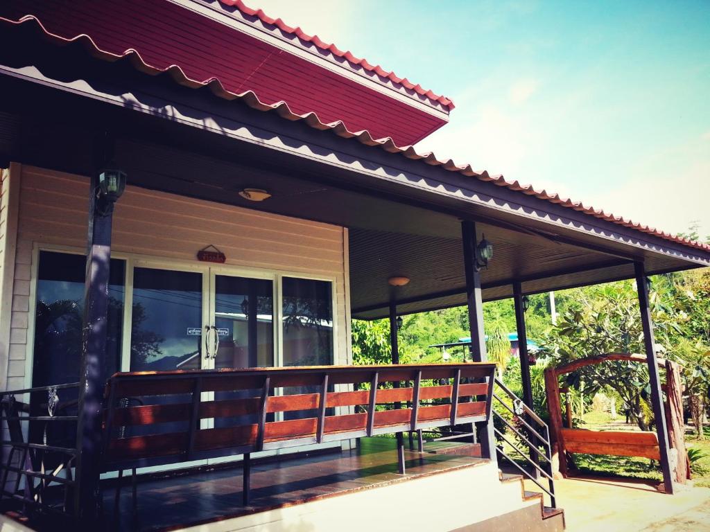 a porch with a bench on a house at Baan Khaoneawdum in Nong Nam Daeng