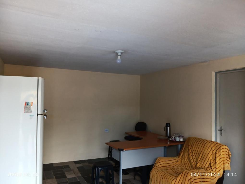 a small room with a table and a refrigerator at Casa confortavel in Ponta Grossa