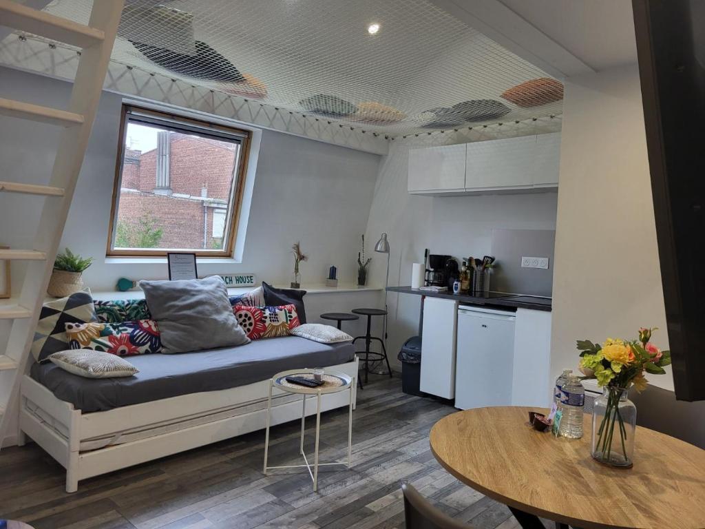 a living room with a couch and a table at La Marine - Centre ville - Wifi in Lens