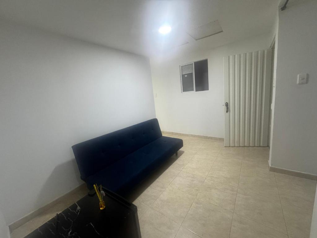 Una sala de estar con un sofá azul en una habitación. en Acogedor Apartaestudio cerca al centro Armenia 3, en Armenia